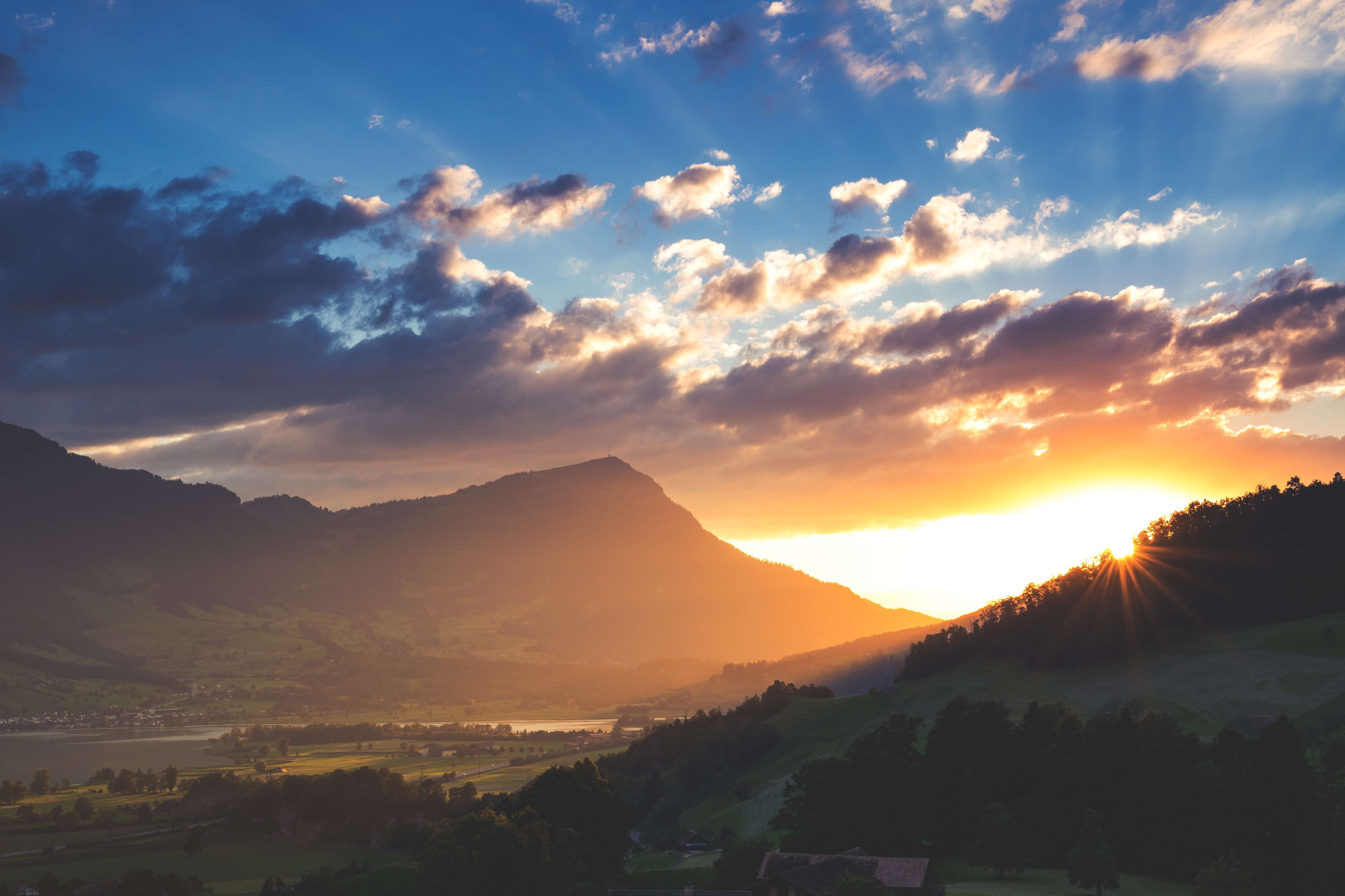 Sunrise through trees on mountains